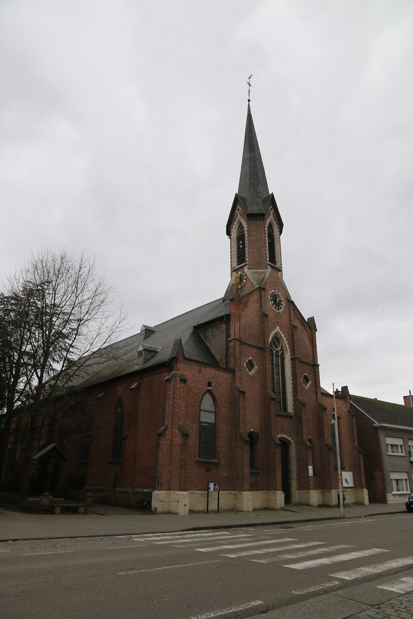Bakstenen parochiekerk Sint-Jan Evangelist in Koningshooikt, met spitse toren